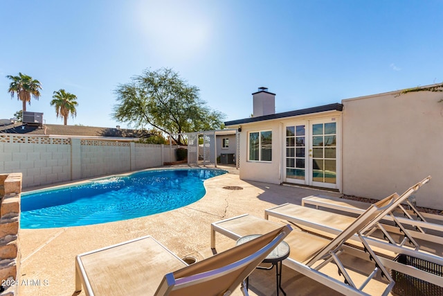 view of pool with central AC, a patio, and french doors