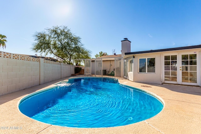 view of pool featuring central air condition unit, a patio area, and french doors