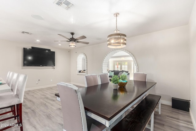 dining space featuring ceiling fan with notable chandelier and light hardwood / wood-style flooring