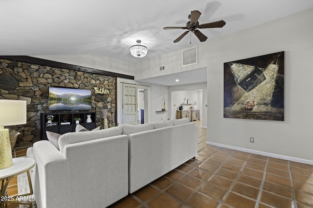 living room featuring dark tile patterned floors, baseboards, and a ceiling fan