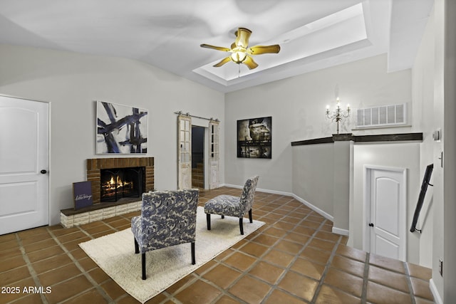 living area featuring a ceiling fan, a fireplace, tile patterned floors, vaulted ceiling, and baseboards