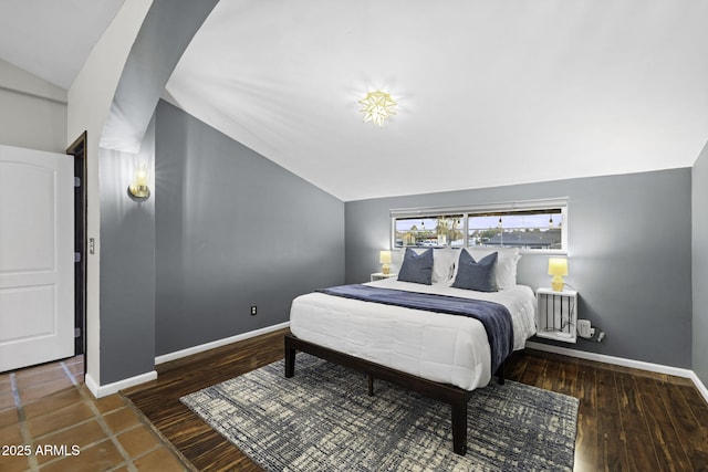 bedroom featuring vaulted ceiling and baseboards
