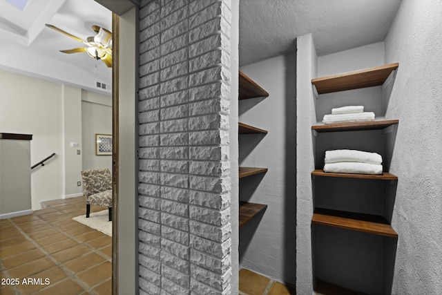 staircase featuring tile patterned floors, ceiling fan, and baseboards