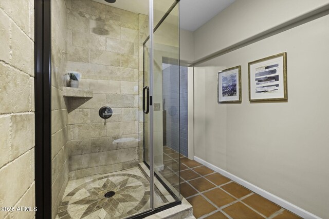 full bathroom featuring a stall shower, tile patterned flooring, and baseboards