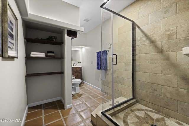 bathroom with a stall shower, vanity, toilet, tile patterned floors, and baseboards