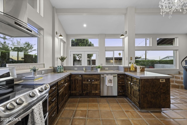kitchen with stainless steel appliances, extractor fan, a sink, dark brown cabinets, and light countertops