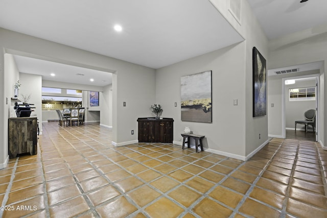 hallway featuring light tile patterned floors, recessed lighting, healthy amount of natural light, and baseboards