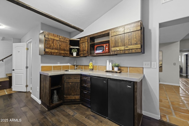 kitchen with a sink, open shelves, fridge, light countertops, and vaulted ceiling