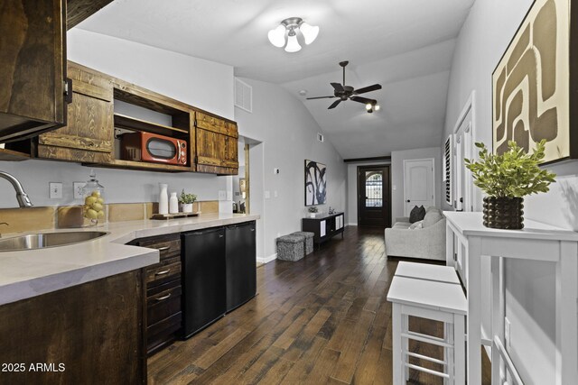 kitchen featuring a sink, dark wood-type flooring, light countertops, lofted ceiling, and open shelves