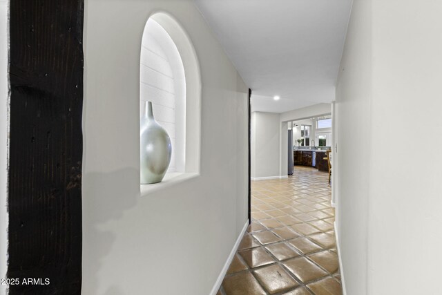 hallway featuring tile patterned flooring and baseboards