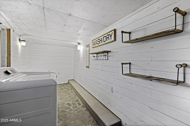washroom with independent washer and dryer and wooden walls