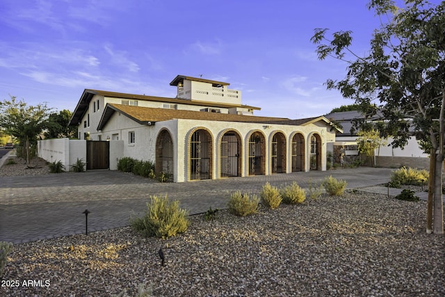 view of front facade featuring stucco siding and fence