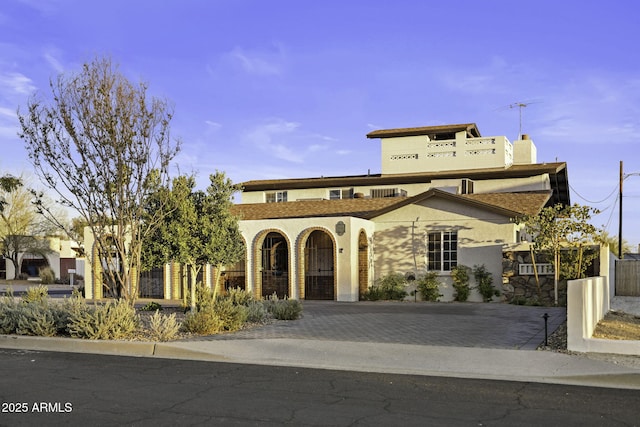 view of front of home with a chimney, stucco siding, and driveway