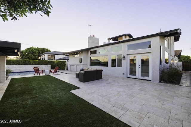 back of house featuring a patio, stucco siding, french doors, and a chimney
