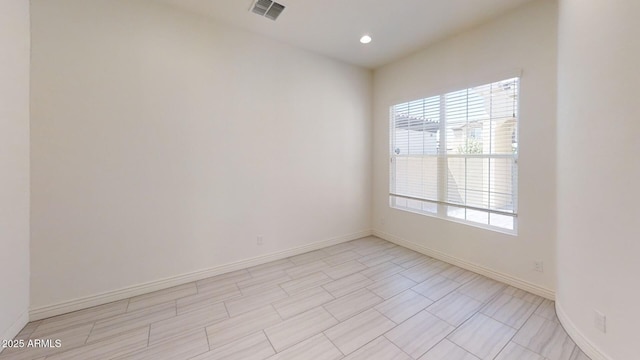 empty room with recessed lighting, visible vents, and baseboards