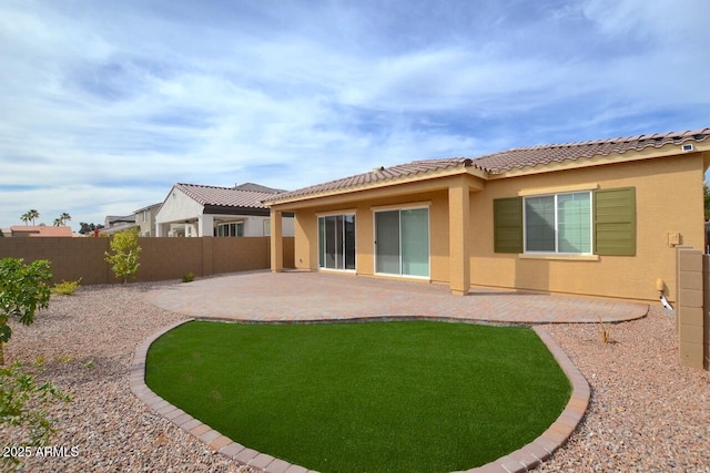 back of house with a patio, a tiled roof, a fenced backyard, and stucco siding