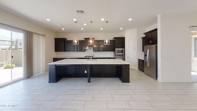 kitchen featuring visible vents, a large island, a sink, stainless steel appliances, and light countertops