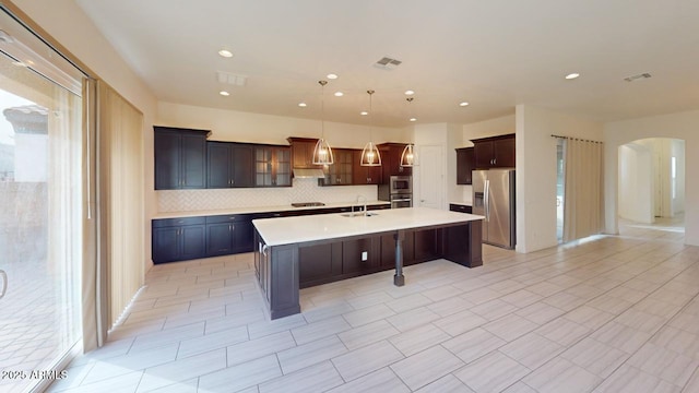 kitchen with stainless steel appliances, arched walkways, visible vents, and light countertops