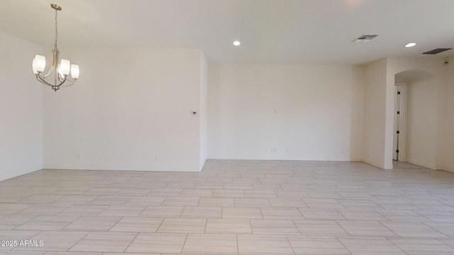 unfurnished room featuring recessed lighting, visible vents, arched walkways, and an inviting chandelier