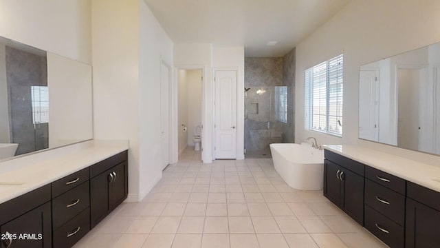 full bath with vanity, a stall shower, a freestanding bath, tile patterned floors, and toilet