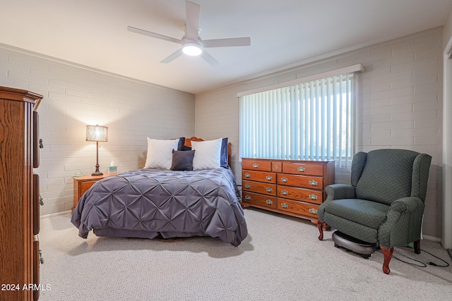 bedroom featuring light carpet, ceiling fan, and brick wall