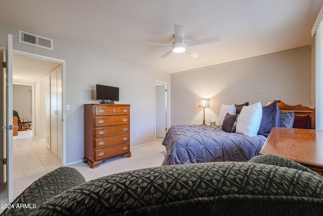 carpeted bedroom with ceiling fan and brick wall