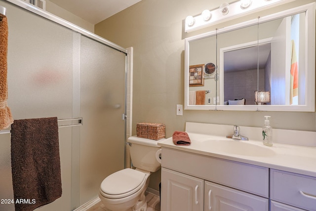 bathroom with a shower with door, vanity, and toilet