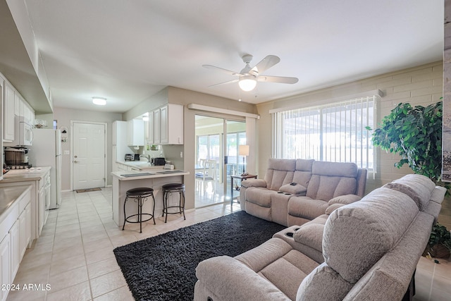 tiled living room featuring ceiling fan and sink