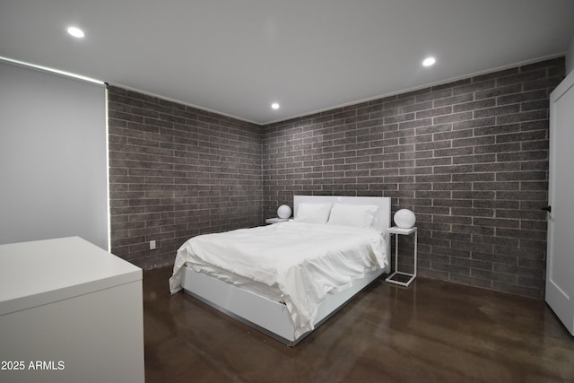 bedroom featuring finished concrete flooring, brick wall, and recessed lighting