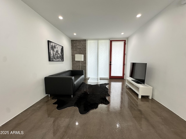 sitting room with finished concrete flooring and recessed lighting