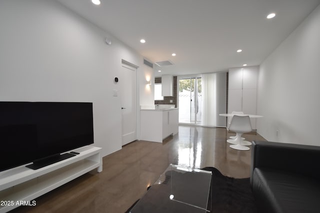 living area featuring visible vents and recessed lighting