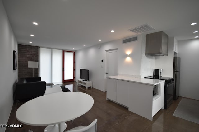 kitchen featuring black electric range, finished concrete flooring, visible vents, and freestanding refrigerator