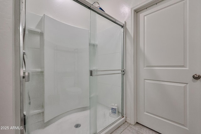 full bathroom featuring a stall shower and tile patterned flooring