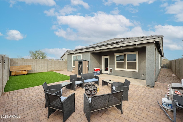 view of patio featuring a fenced backyard, central AC, and an outdoor living space with a fire pit