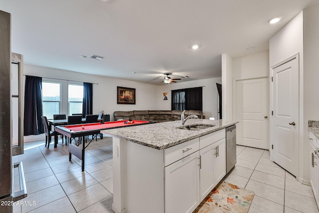 kitchen with light tile patterned floors, visible vents, white cabinets, a sink, and stainless steel dishwasher