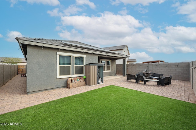 rear view of house with a patio area, a yard, a fenced backyard, and stucco siding