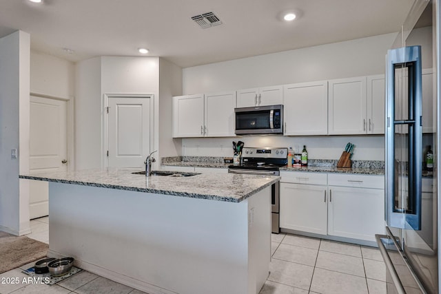 kitchen with visible vents, appliances with stainless steel finishes, light stone counters, a sink, and light tile patterned flooring