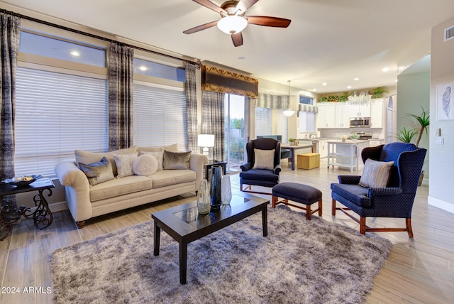 living room featuring ceiling fan and light hardwood / wood-style flooring