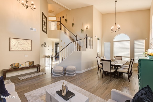 living room with a notable chandelier, hardwood / wood-style flooring, and high vaulted ceiling