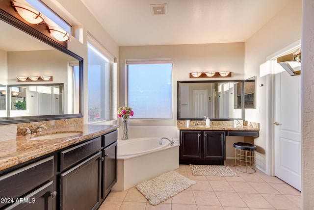 bathroom with vanity, a tub to relax in, tile patterned floors, and a wealth of natural light