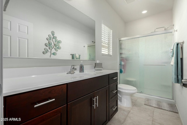 bathroom with vanity, a shower with door, tile patterned floors, and toilet