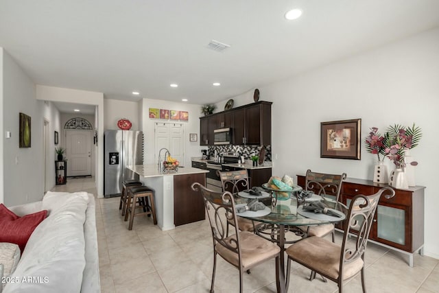 dining room featuring sink and light tile patterned flooring