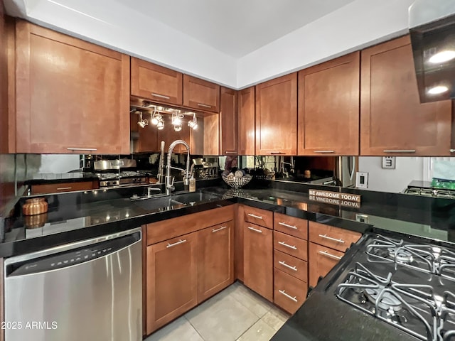 kitchen featuring dishwasher, dark stone countertops, sink, and light tile patterned flooring