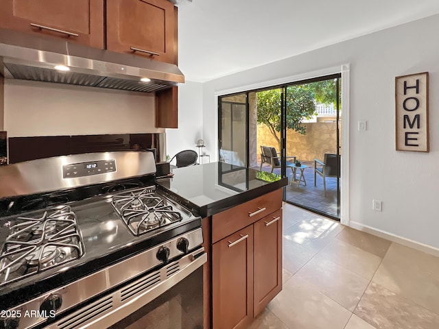 kitchen with stainless steel range with gas cooktop, light tile patterned floors, and range hood