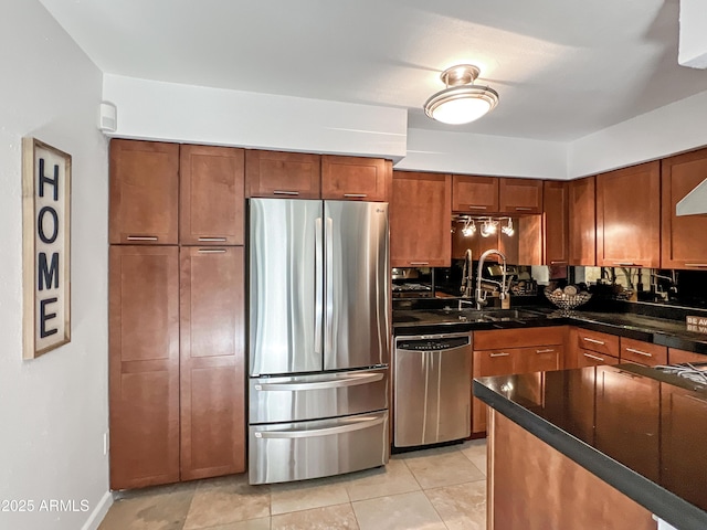 kitchen with dark stone countertops, appliances with stainless steel finishes, sink, and light tile patterned floors