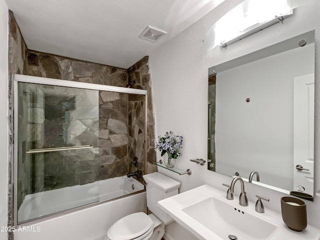 full bathroom with shower / bath combination with glass door, toilet, sink, and a textured ceiling