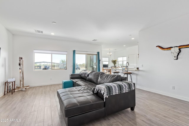 living room featuring an inviting chandelier and light wood-type flooring