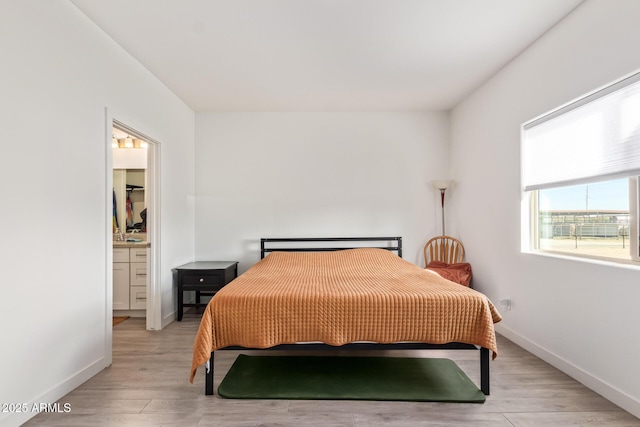 bedroom featuring a spacious closet and light wood-type flooring