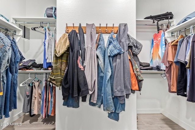 walk in closet with light wood-type flooring