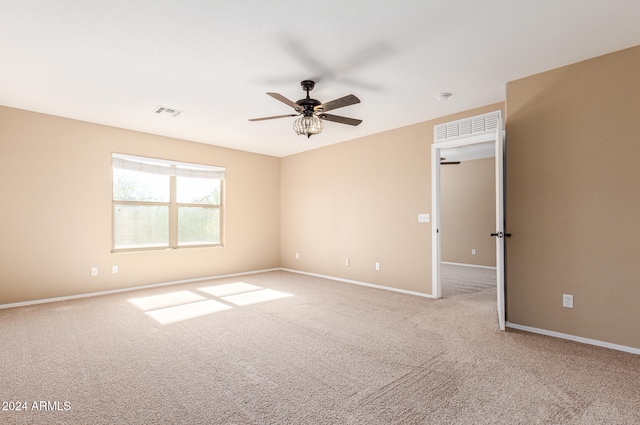 spare room with ceiling fan and light colored carpet